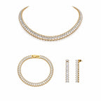 Pure Glow Schmuck Set mit goldfarbener Kette, Armband und Ohrringen mit klaren, rechteckigen Zirkonia Elementen, minimalistisch auf reinweißem Hintergrund.