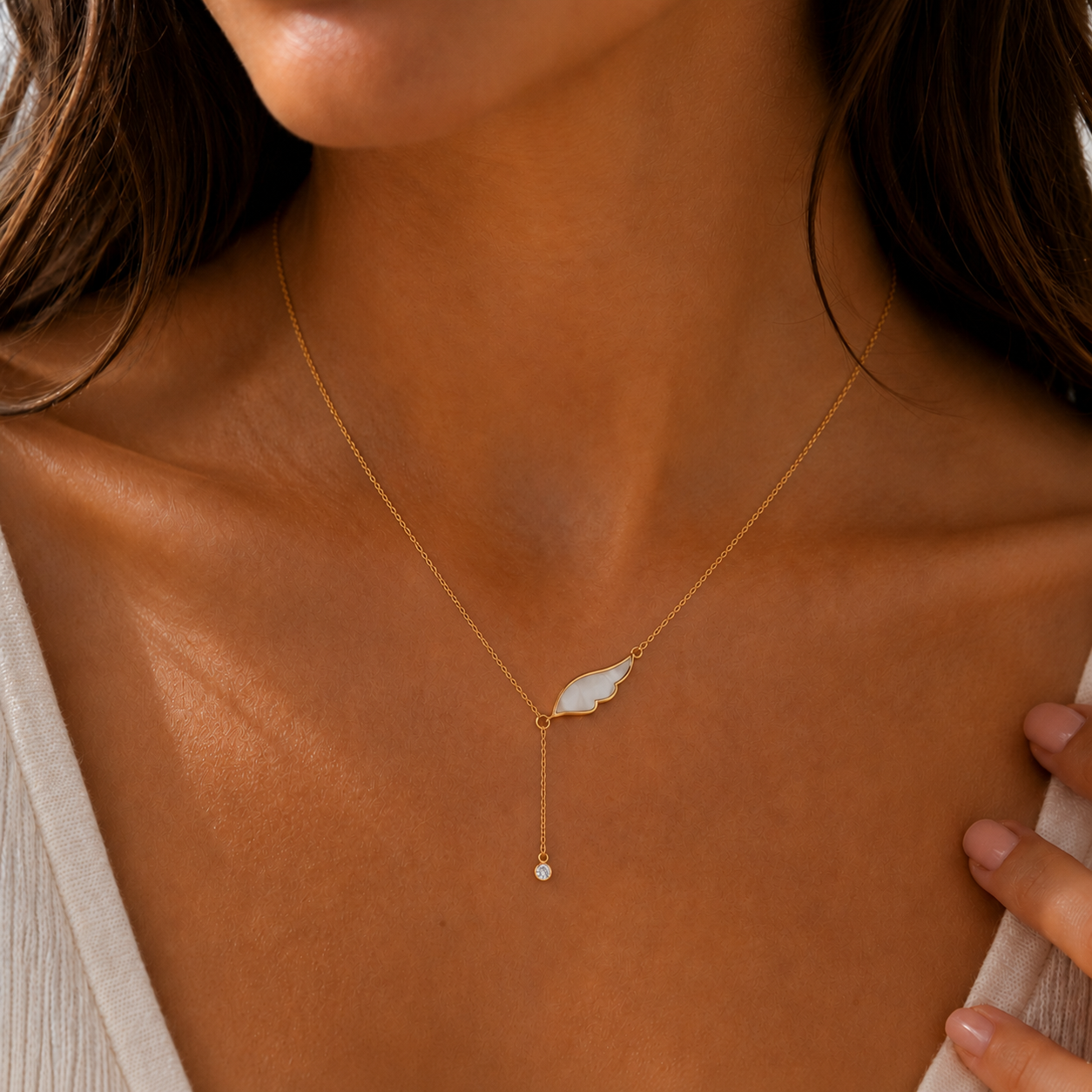 Frau trägt Angel Wing Kette mit weißem Engelsflügel Anhänger in Gold