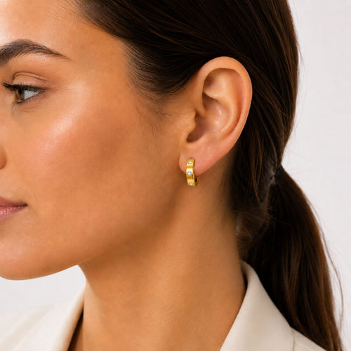 Goldene Creolen Ohrringe mit Zirkonia Steinen elegant am Ohr getragen