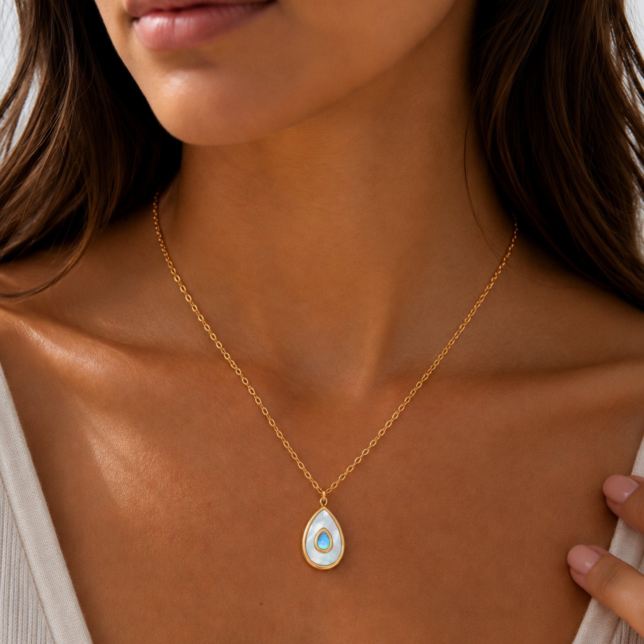 Frau trägt Blue Aura Drop Kette mit blauem Opal Tropfen Anhänger in Gold