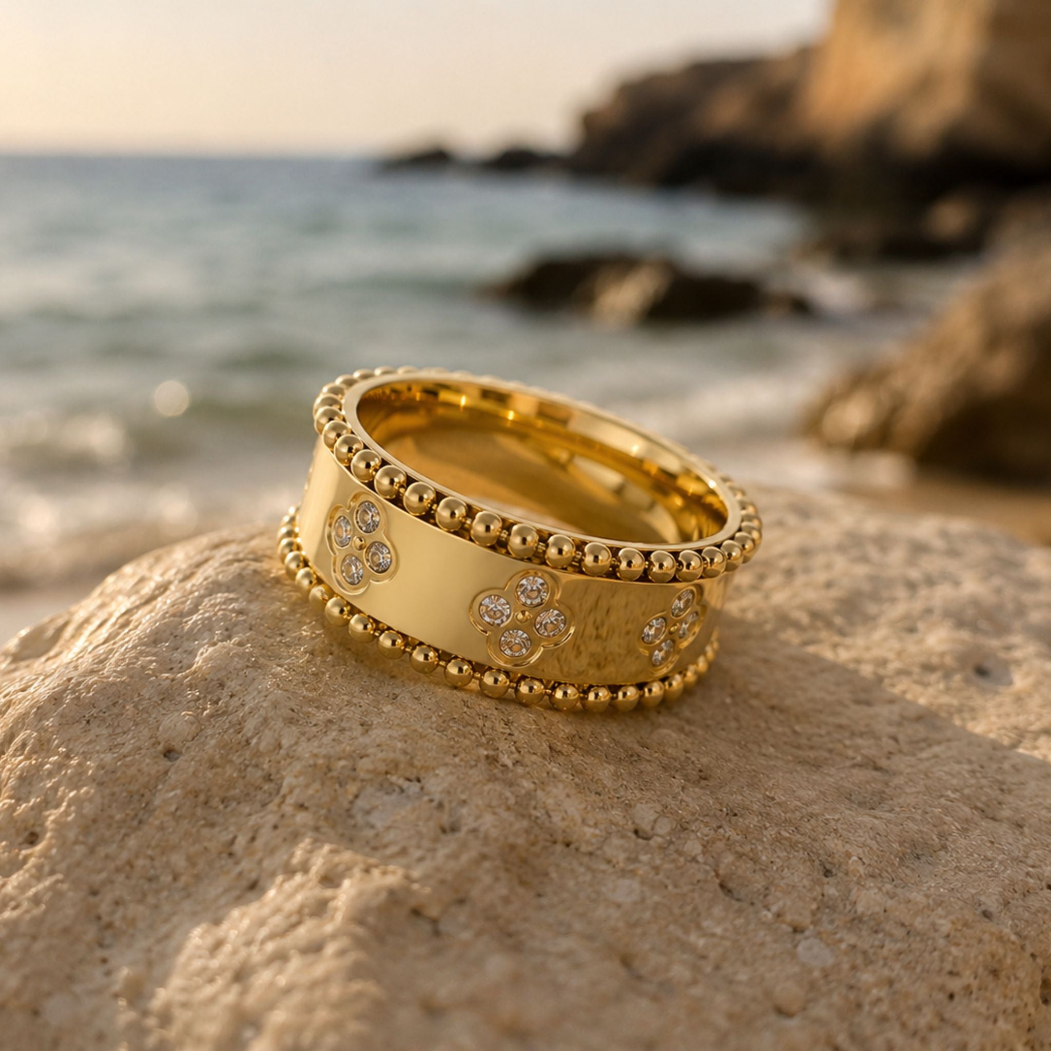 Goldener Ring mit Kleeblatt Zirkonia Details auf Naturstein inszeniert