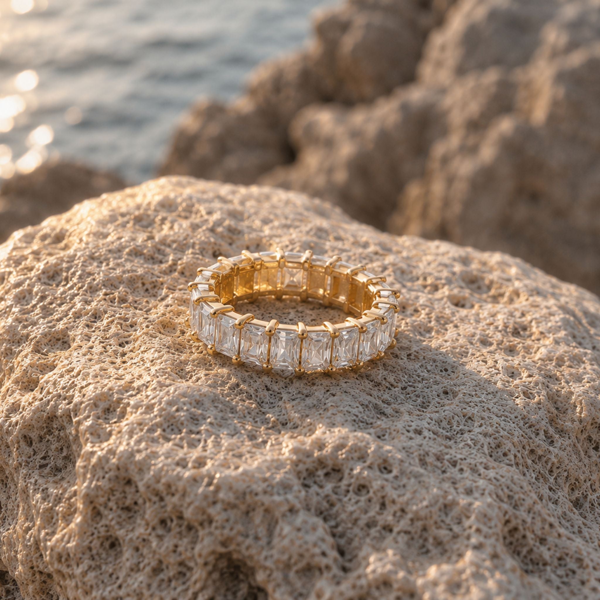 Goldener Zirkonia Eternity Ring auf Naturstein am Strand