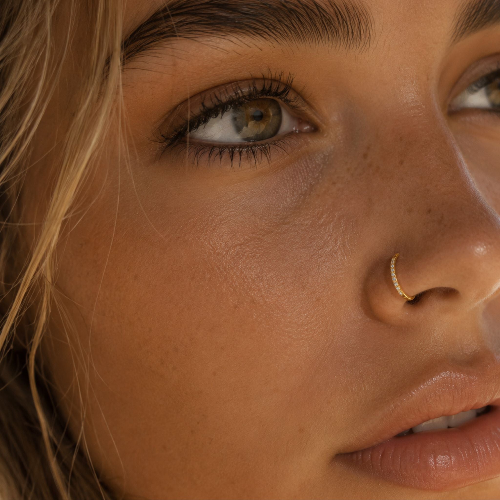 Eternal Glow Nasenpiercing Gold mit Zirkonia getragen am Nasenflügel