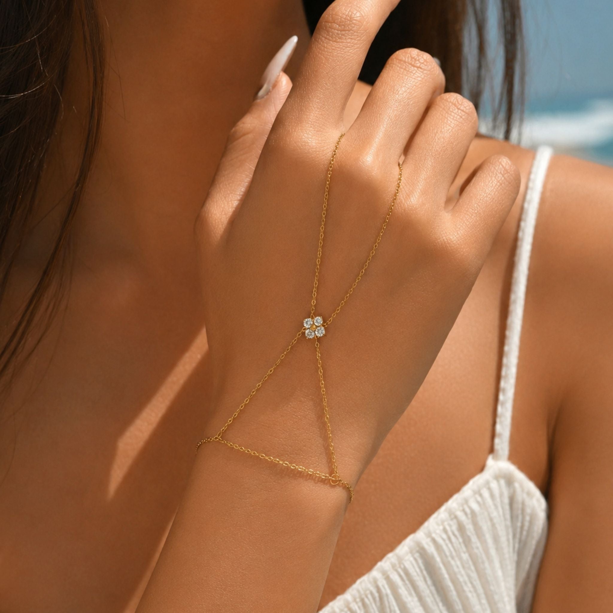 Goldene Handkette mit Blumenmotiv und funkelnden Zirkonia Steinen