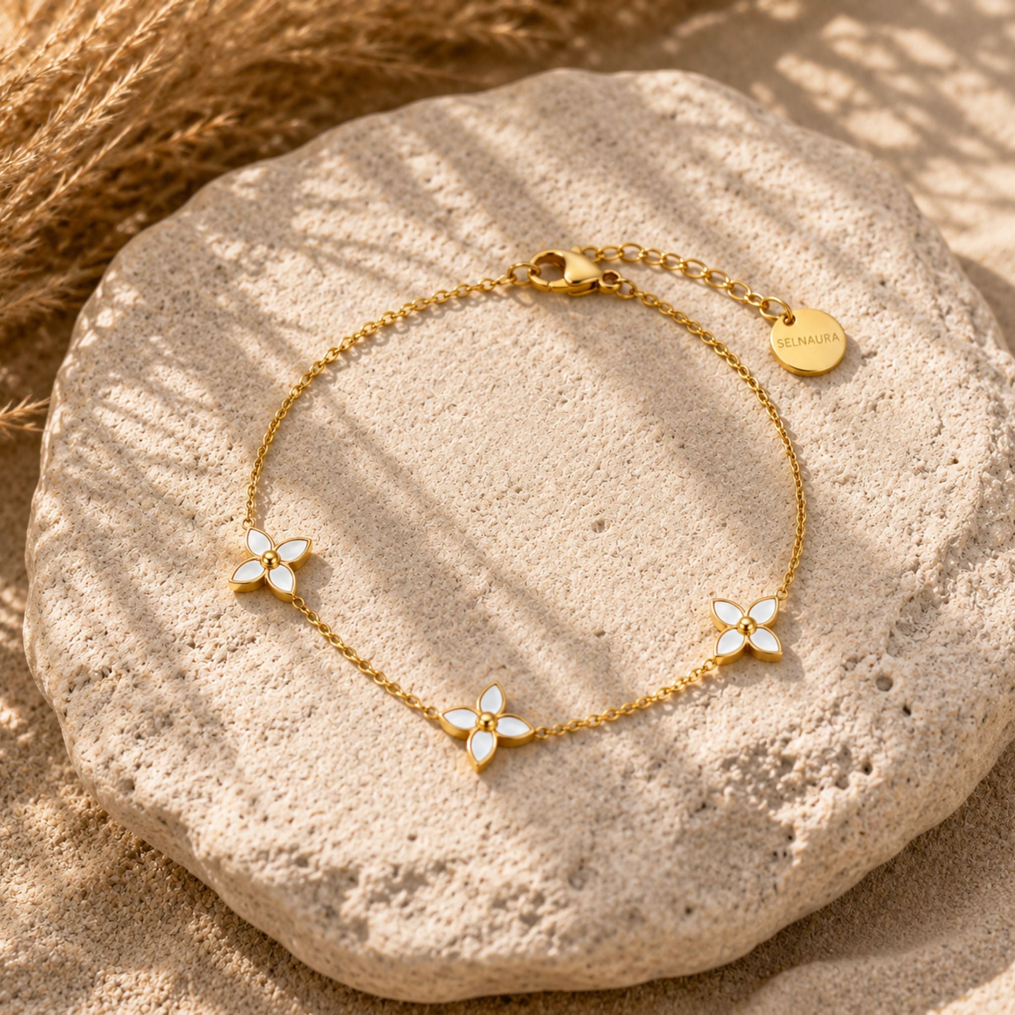 Flora Pearl Armband in Gold mit Perlmuttblüten auf Naturstein präsentiert