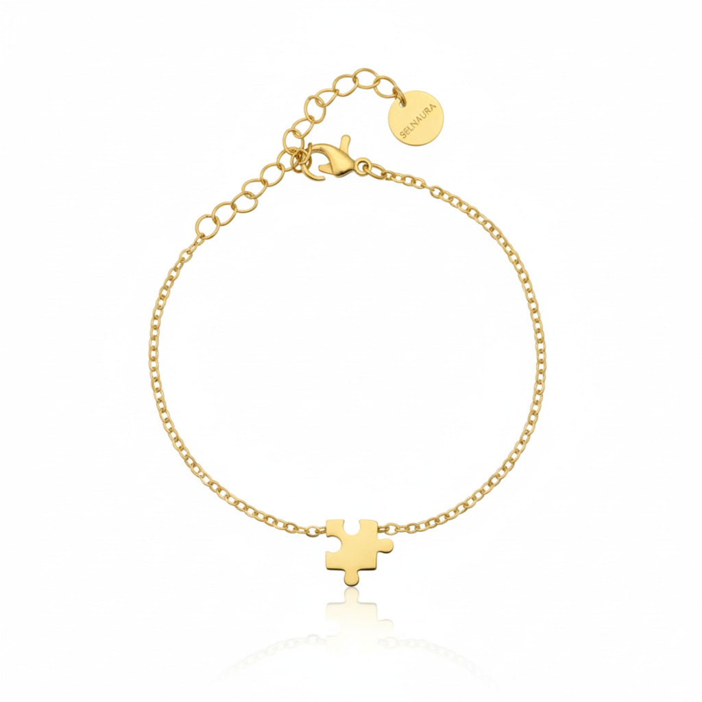 Goldenes Eternité Piece Armband mit Puzzle-Symbol, minimalistisches Damenarmband aus Edelstahl auf weißem Hintergrund