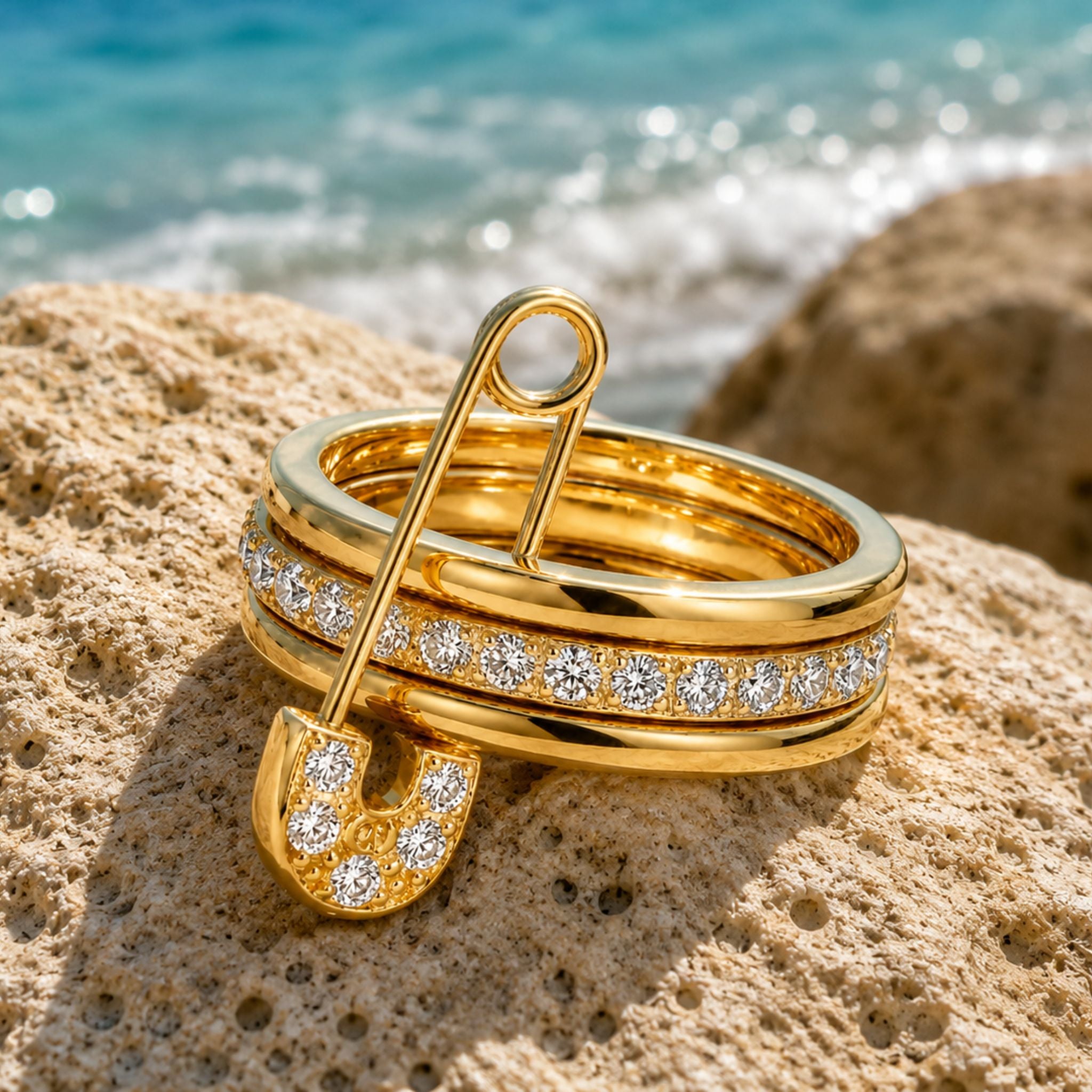 Goldener Edelstahl Ring mit Sicherheitsnadel und Zirkonia auf Naturstein