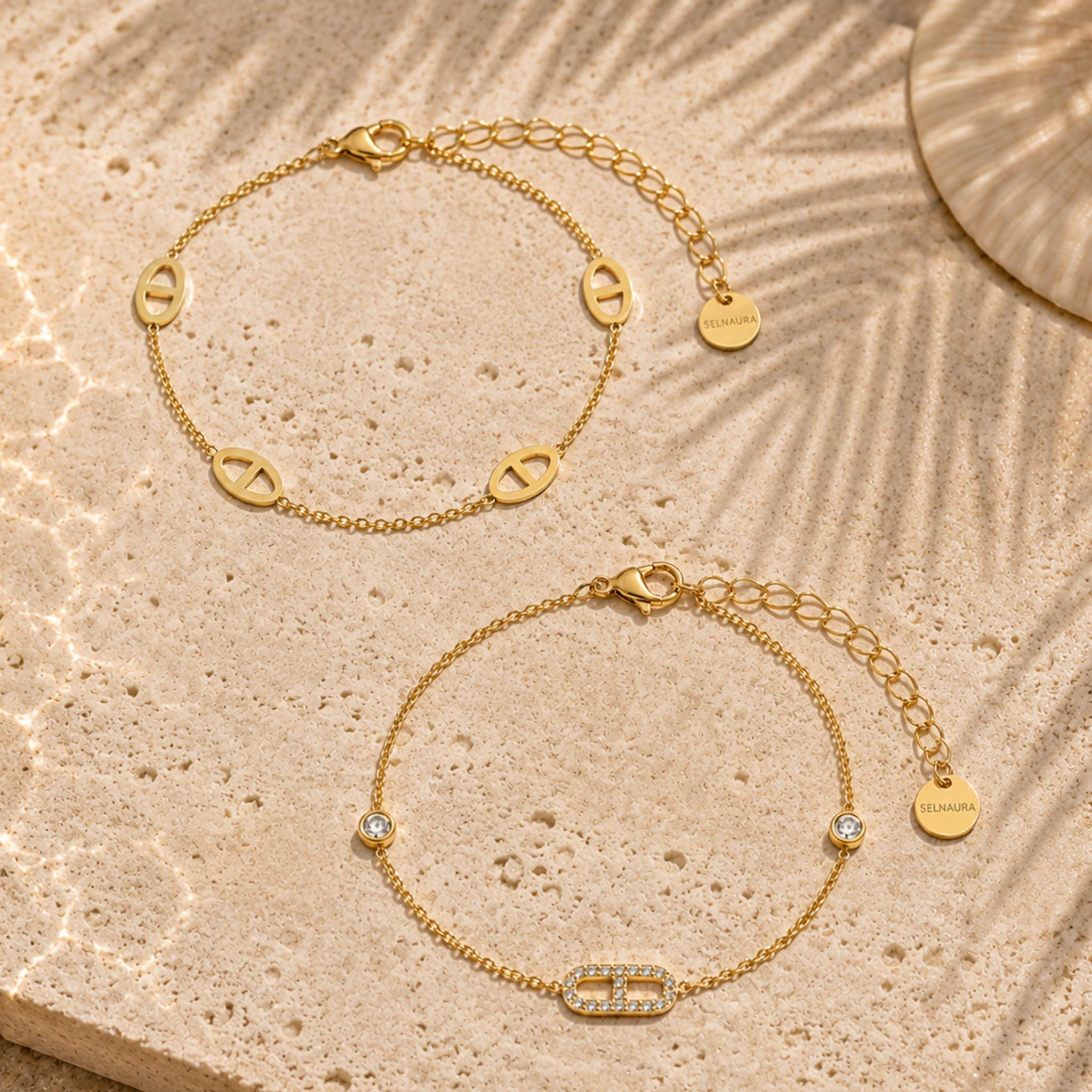 Monaco Set aus goldfarbenem Armband und Fußkette auf Naturstein mit luxuriösem Glanz