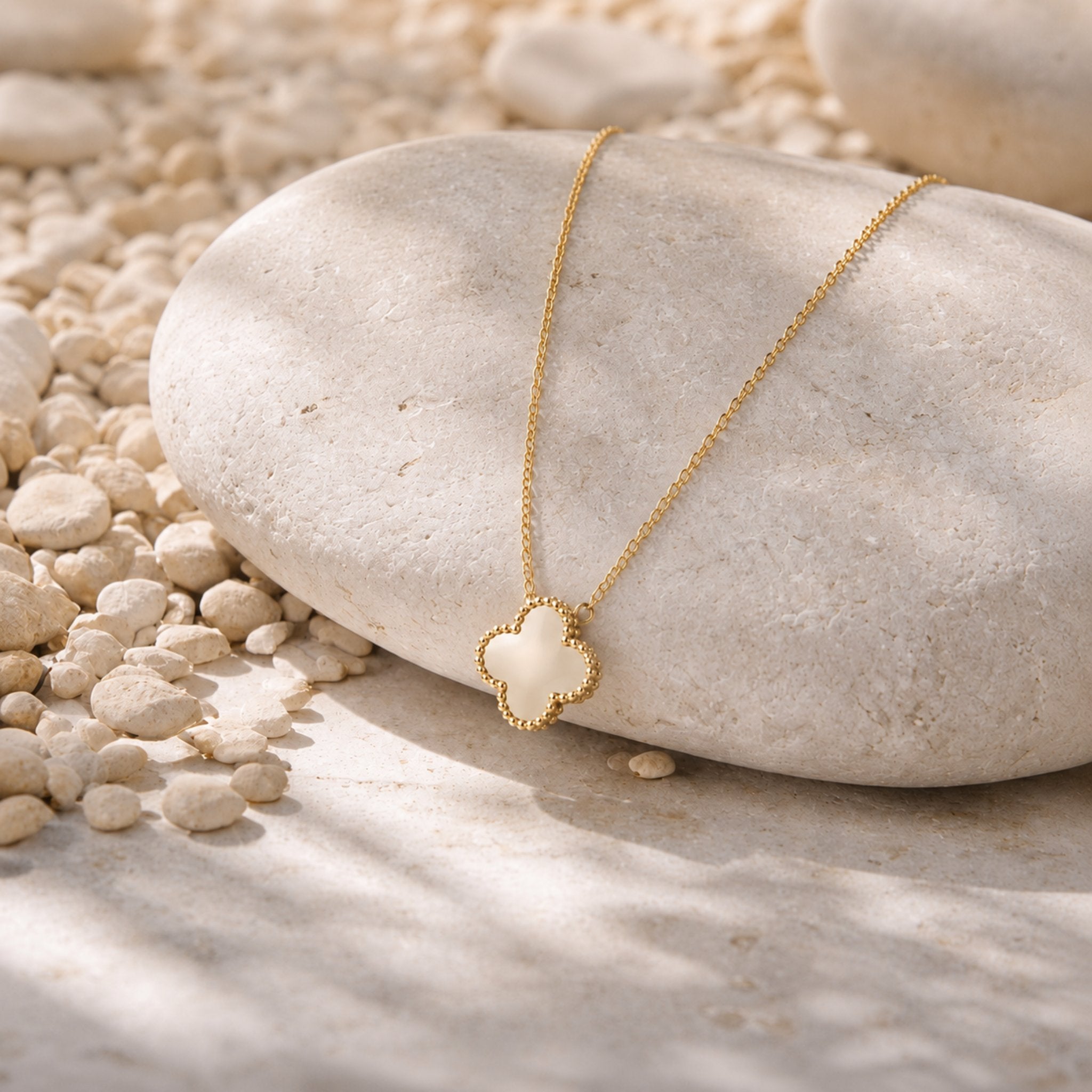 Pearl Clover Kette mit weißem Kleeblatt Anhänger auf hellem Naturstein präsentiert