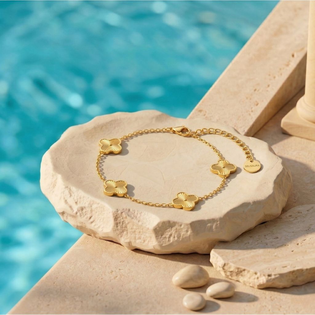 Goldfarbenes Kleeblatt-Armband mit strukturierten Anhängern am Pool auf Naturstein – wasserfestes Damen Armband von Selnaura, hautfreundlich und kein Abfärben – Selnaura Golden Bloom Clover Armband