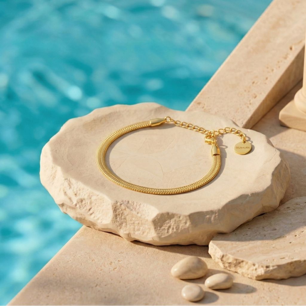Goldfarbenes flaches Schlangen-Armband auf Naturstein am Pool – wasserfestes Damen Armband von Selnaura, hautfreundlich und kein Abfärben – Selnaura Liquid Flow Snake Armband