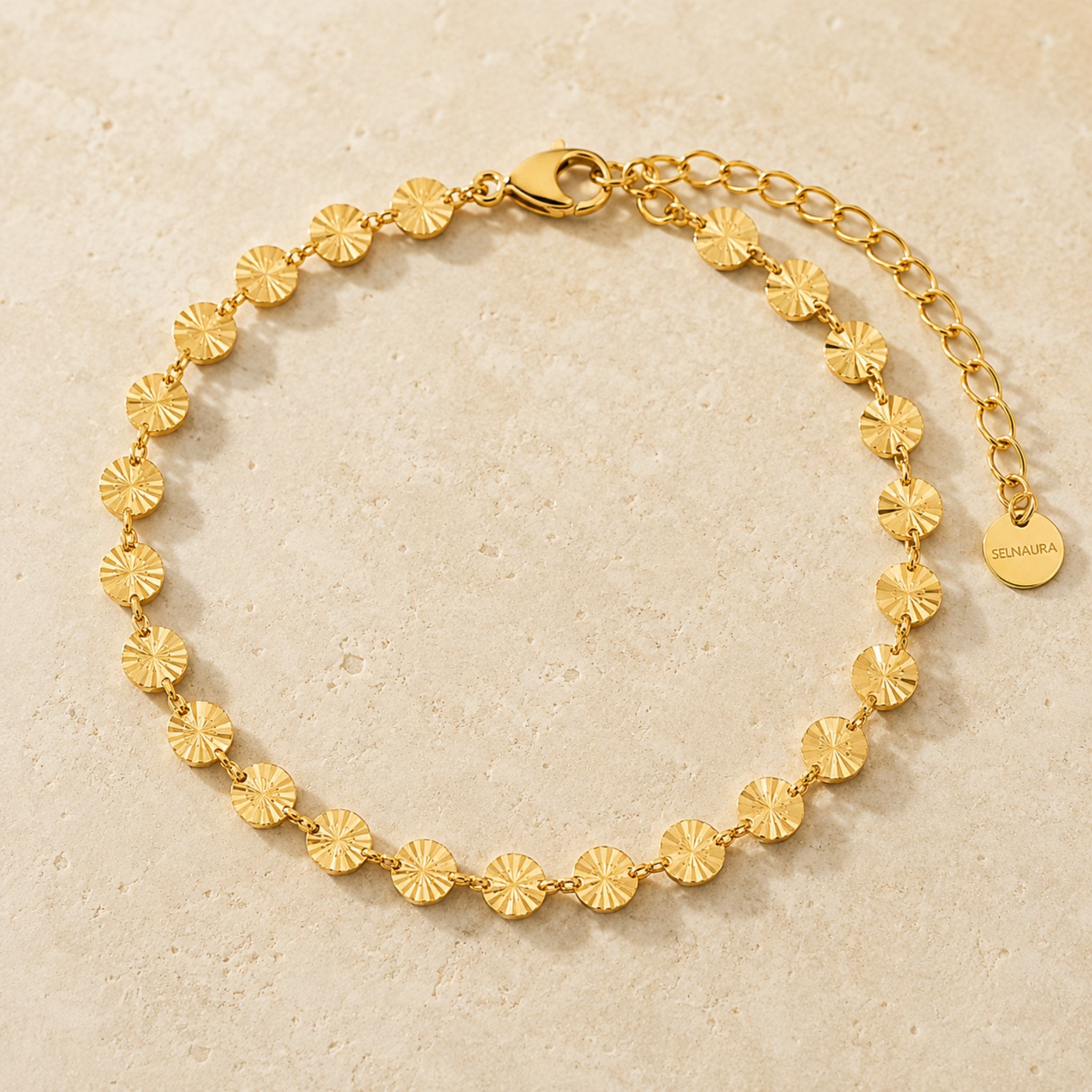 Goldenes Soleil Armband auf hellem Naturstein dekoriert