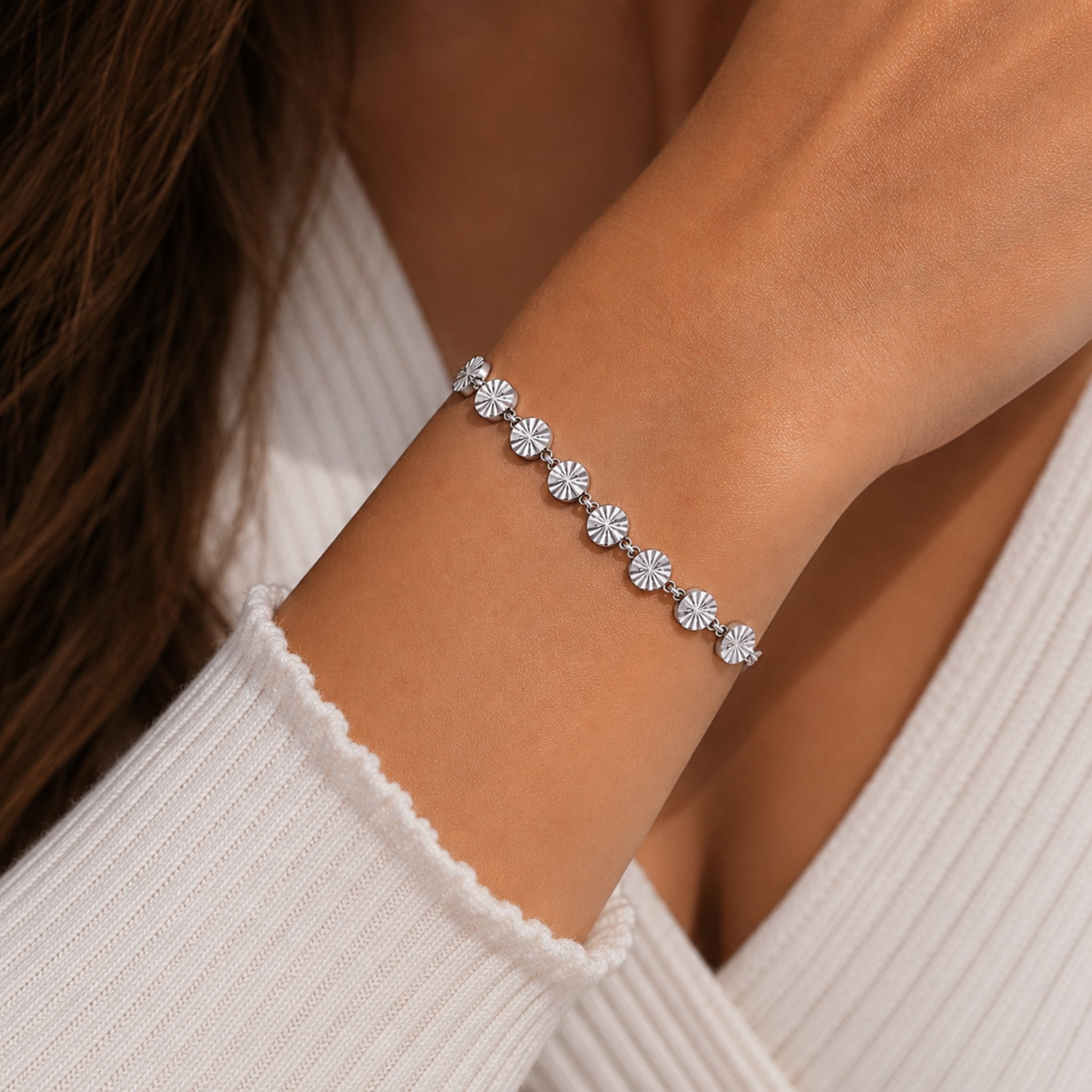 Dame trägt silbernes Soleil Armband mit glänzenden Plättchen