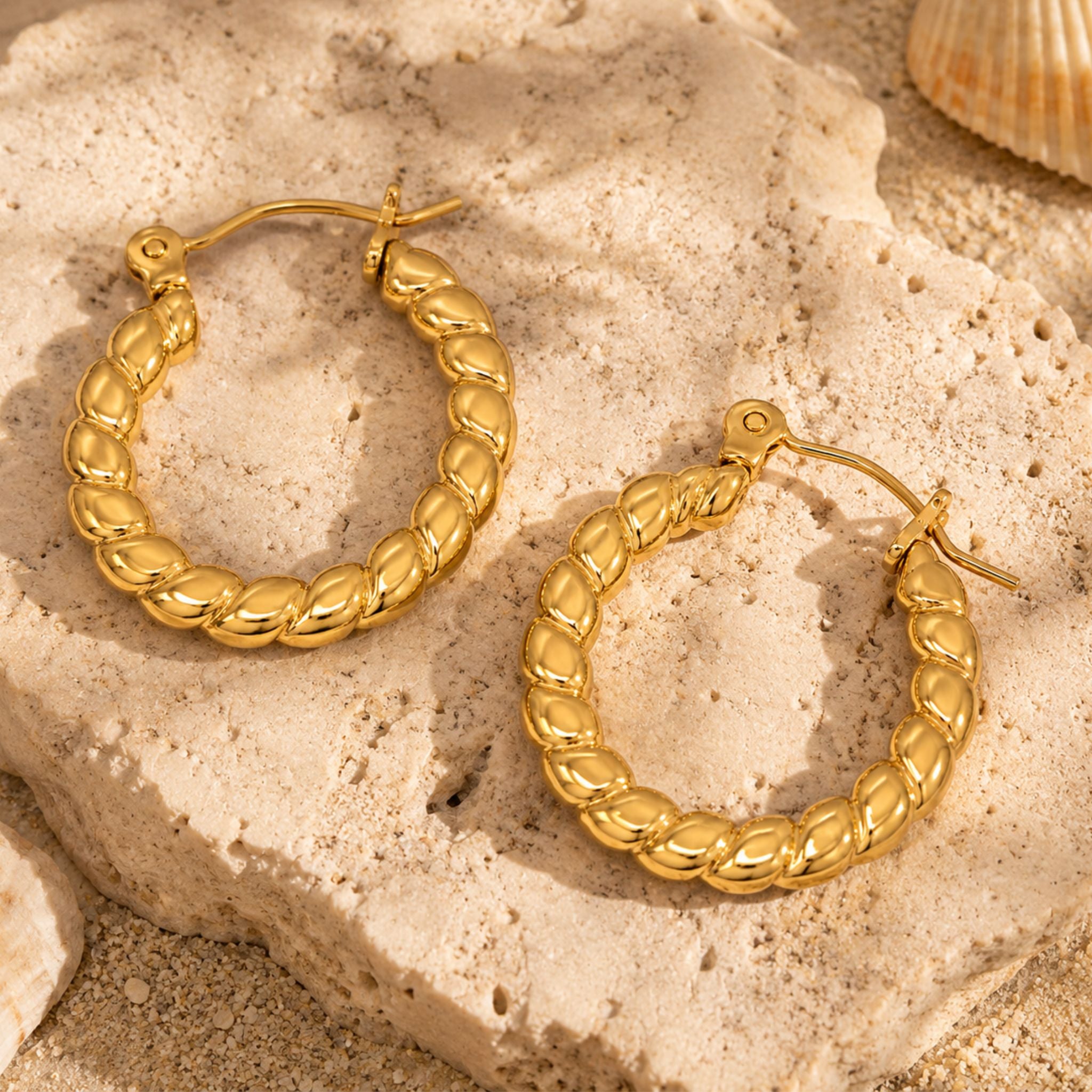 Twist Creolen Gold aus Edelstahl auf Naturstein stilvoll präsentiert